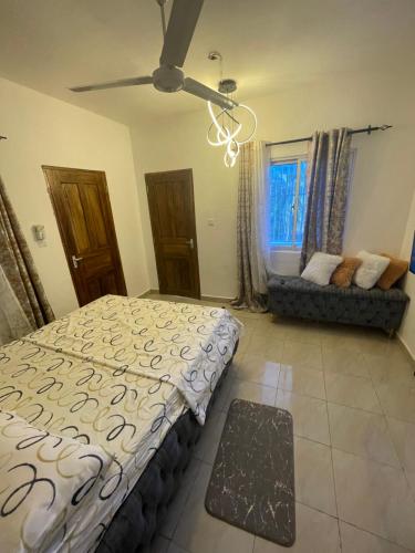 a bedroom with a bed and a window with a couch at Ailynes in Diani Beach