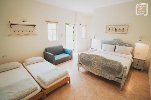 a bedroom with two beds and a blue chair at SATTAHIP Zentobu House in Ban Tao Than