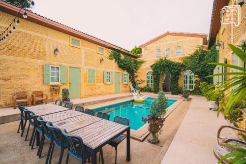 a patio with a table and chairs next to a pool at SATTAHIP Zentobu House in Ban Tao Than