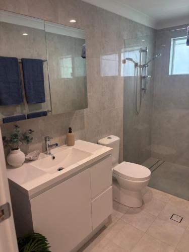 a bathroom with a sink and a toilet and a shower at Beach Side Getaway Lighthouse Beach in East Ballina