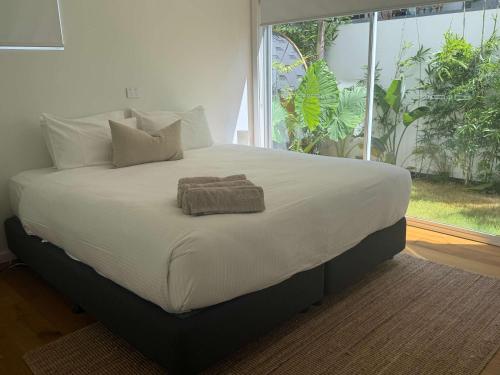 a large bed in a bedroom with a large window at El Parche Bilinga Beachside, Unit 5, Sleeps 6 in Gold Coast