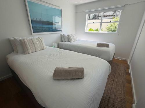 two beds in a small room with two windows at El Parche Bilinga Beachside, Unit 5, Sleeps 6 in Gold Coast