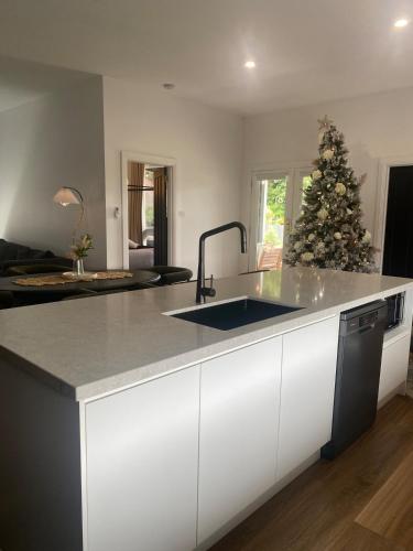 a kitchen with a christmas tree in the background at Elegant 3br Haven with Character & Charm in Yarram