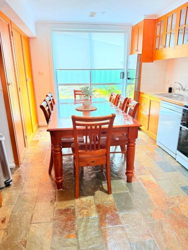 a kitchen with a table with chairs and a large window at Spacious Apartment with the view of Mt. Wellington in Lenah Valley