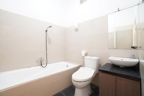 a white bathroom with a toilet and a sink at Kamar Bagus in Jakarta