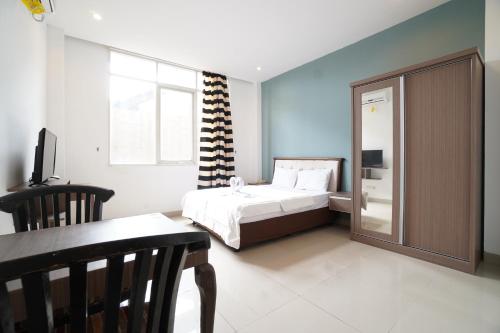 a bedroom with a bed and a table and a window at Kamar Bagus in Jakarta
