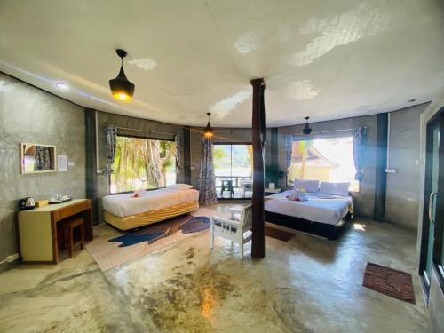 a large room with two beds and a desk and a room with at Family view A4 -Kantiang paradise resort- in Ko Bu Bu