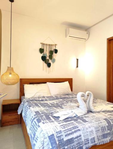 two swans sitting on a bed in a bedroom at Coconut Villa in Kerobokan
