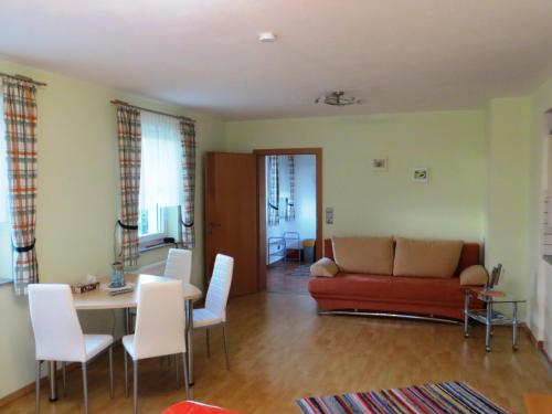 sala de estar con sofá, mesa y sillas en Ferienwohnungen Bauernhof Schilcher en Sankt Stefan im Lavanttal