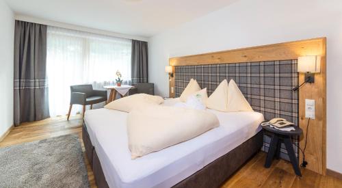 a bedroom with a large white bed in a room at Hotel Hubertus in Sölden