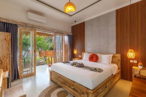 a bedroom with a large bed and a balcony at La Semaya Beach Villas in Nusa Penida
