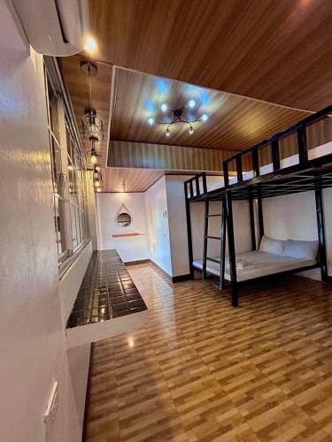 a room with two bunk beds and a wooden floor at KNB West Villa Inn by SMS Hospitality in Bolinao