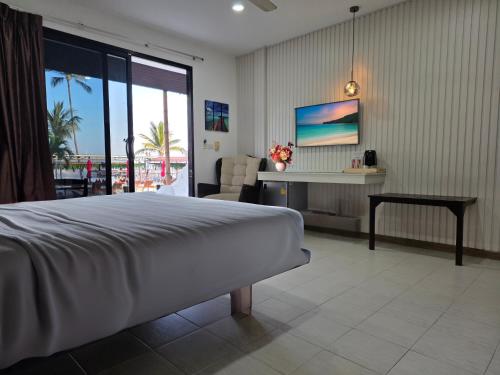 a bedroom with a bed and a desk with a view at Samui Pier Beach Front & Resort in Bangrak Beach