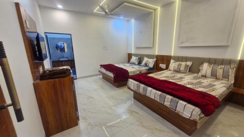 a bedroom with two beds and a mirror at Shri Balaji Resort in Ellora