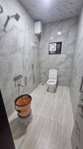 a white bathroom with a toilet and a sink at Shri Balaji Resort in Ellora
