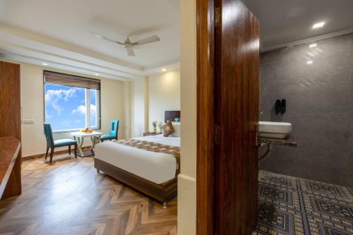a bedroom with a bed and a bathroom with a sink at Hotel Neu Villa, City Centre - Near Connaught Place & NDLS Station in New Delhi