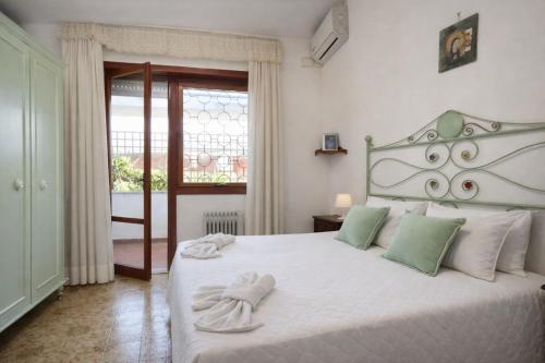 a bedroom with a white bed with towels on it at Villa summertime walking distance from the sea with garden in Fregene
