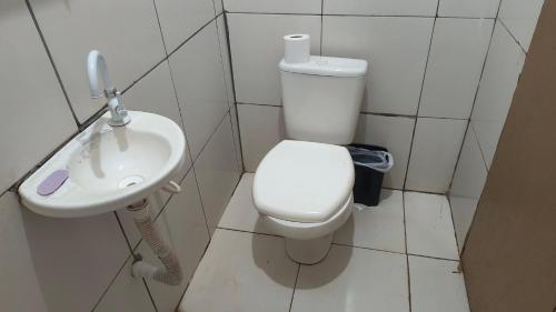 a bathroom with a toilet and a sink at Pousada RC Q2 in Várzea Grande