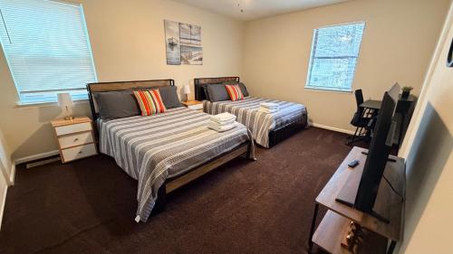 a bedroom with two beds and a flat screen tv at Cozy home with BBQ -5 min Braves in Atlanta