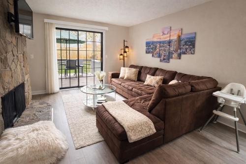 a living room with a brown couch and a fireplace at Cozy home with BBQ -5 min Braves in Atlanta