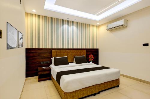 a bedroom with a large bed in a room at Townhouse Oak Ram Lala Mandir Kanpur Formerly Hotel Sun Rise in Kaliānpur