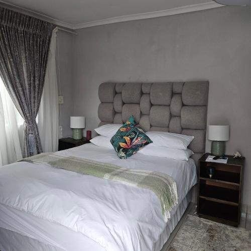 a bedroom with a large white bed with two lamps at 14 Isabel Room 2 in Centurion
