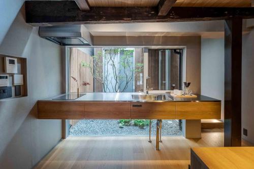 a bathroom with a sink and a large mirror at Itose Machiya House in Kanazawa