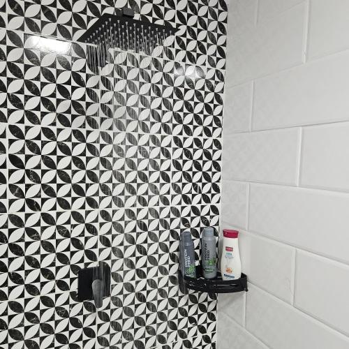 a bathroom with a black and white tiled wall at 14 Isabel Room 2 in Centurion