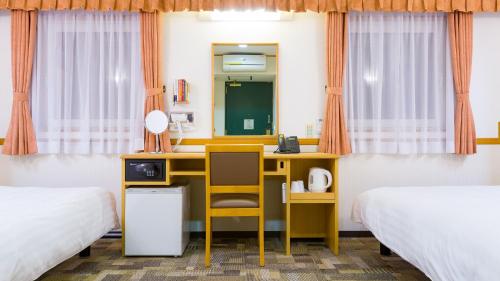 a desk in a room with two beds and a mirror at Toyoko Inn Oyama eki Higashi guchi No 1 in Oyama