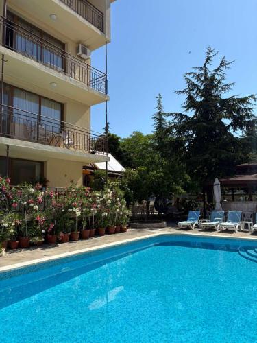 a swimming pool in front of a building at Family Hotel Chris in Sveti Vlas