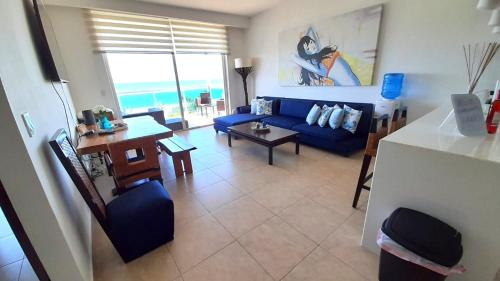 a living room with a blue couch and a table at Nikki Beach Oceanfront Penthouse in Río Hato