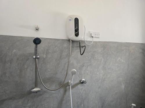 a shower with a phone attached to a wall at Shayon Villa in Hiriketiya