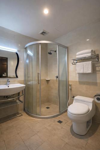 a bathroom with a shower and a toilet and a sink at Atari Inn Tawau in Tawau