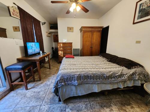 a bedroom with a bed and a desk with a computer at Vizcaino Departamento con cocina in Ensenada