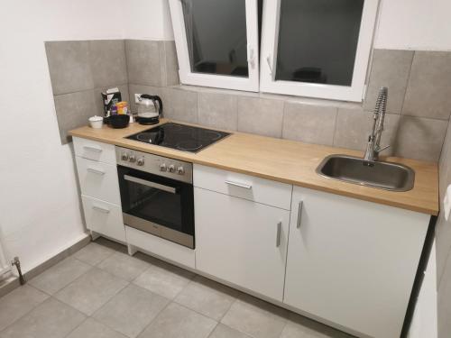a kitchen with white cabinets and a sink at Modernes Studio in Sonderheim-Germersheim in Germersheim