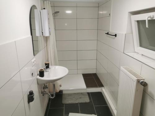 a white bathroom with a sink and a shower at Modernes Studio in Sonderheim-Germersheim in Germersheim