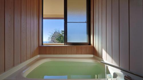 a bath tub in a bathroom with a window at 筑波山江戸屋 in Tsukuba