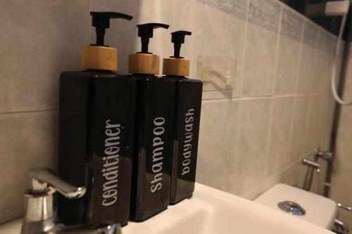 a group of three bottles sitting on top of a sink at PortDickson Sakura 10Pax 3BR Glory Beach Resort Suite in Port Dickson