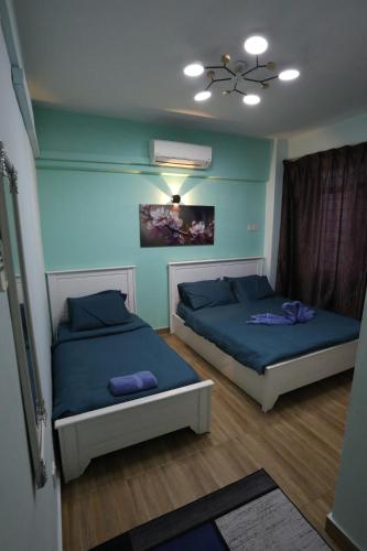 two beds in a room with blue walls at PortDickson Sakura 10Pax 3BR Glory Beach Resort Suite in Port Dickson