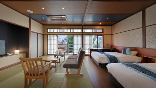 a hotel room with two beds and a table and chairs at 筑波山江戸屋 in Tsukuba
