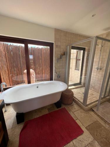 a large bathroom with a tub and a large window at Luxury Villa at Elements Golf Course - Bela Bela in Warmbaths