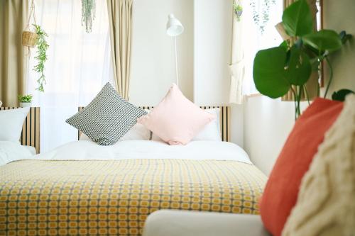 a bedroom with a bed with pillows on it at Nagi Takamatsu 702 in Takamatsu