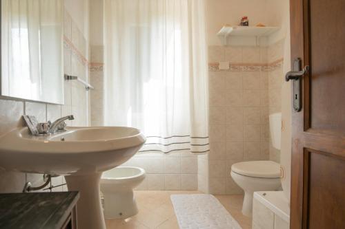 a white bathroom with a sink and a toilet at Appartamenti Quintavalle in Casa Marchetti