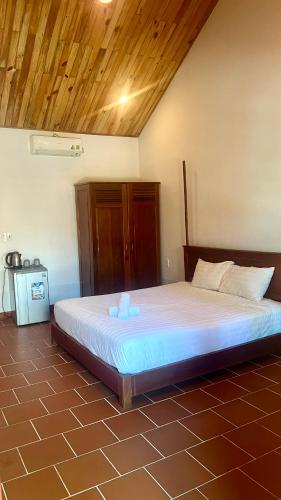 a large bed in a room with a wooden ceiling at Sam Ong Lang Homestay in Phú Quốc