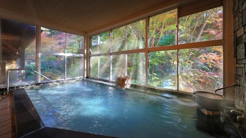 a large pool of water in a room with a large window at 筑波山江戸屋 in Tsukuba