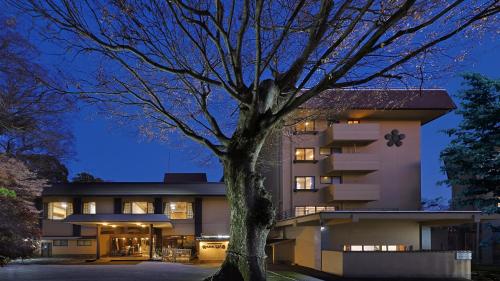 a building with a tree in front of it at 筑波山江戸屋 in Tsukuba