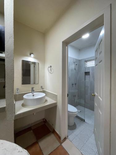 a bathroom with a sink and a toilet and a shower at Hotel Dos Mundos, Isla Cozumel in Cozumel