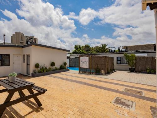 a patio with a wooden table and a building at La Bella Vida Self Catering Apartments in Bellville