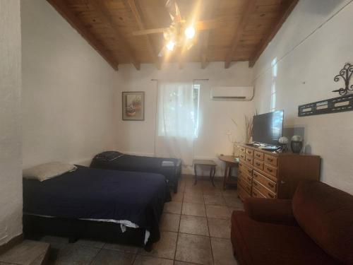 a bedroom with two beds and a tv and a couch at Casa Jardines in Mexicali