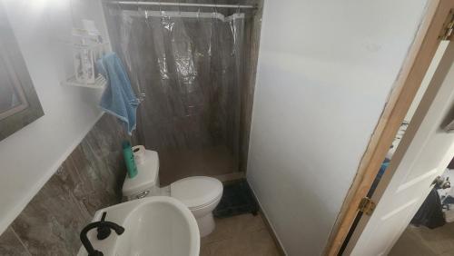 a bathroom with a toilet and a shower and a sink at Casa Jardines in Mexicali